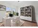 Bright office with two windows, modern desk, bookshelf, and wood floors at 5516 Madrigal Way, Apollo Beach, FL 33572