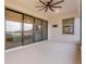 The covered patio has sliding glass doors, a ceiling fan, and a view of the water at 5516 Madrigal Way, Apollo Beach, FL 33572