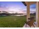 A backyard patio with outdoor seating overlooks a pond and beautiful sunset at 5516 Madrigal Way, Apollo Beach, FL 33572