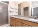 Bathroom with double sinks, granite countertop, wood cabinets and shower with tile detail at 2353 Max Ct, New Port Richey, FL 34655