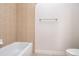 A neutral colored bathroom features a white tub, chrome towel bar, and a white toilet in the background at 2353 Max Ct, New Port Richey, FL 34655