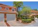 Two-story villa featuring an attached garage, brick driveway, and tropical landscaping at 2353 Max Ct, New Port Richey, FL 34655