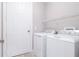 Clean laundry room features a white washer and dryer, wire shelving, and white door at 2353 Max Ct # 28, New Port Richey, FL 34655