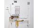 Close up of a wall-mounted Takagi tankless water heater and associated plumbing at 2353 Max Ct, New Port Richey, FL 34655