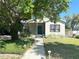 Charming home featuring a well-manicured lawn, walkway, and a cozy front porch at 3025 W North A St, Tampa, FL 33609