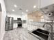 Well-lit kitchen features stainless appliances, granite counters, and white cabinetry at 3025 W North A St, Tampa, FL 33609