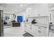 Open kitchen with white cabinets and stainless appliances, with a view to living room at 4335 S Coolidge Ave, Tampa, FL 33611