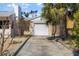 Exterior view of a garage with a clean, white door, framed by lush palm trees and vibrant bougainvillea at 437 79Th Ave, St Pete Beach, FL 33706