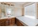 Bright bathroom featuring a hot tub next to a large window and a vanity with a full-size mirror at 8226 36Th N Ave, St Petersburg, FL 33710