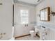 Outdated bathroom featuring a pedestal sink, toilet, window, medicine cabinet, and wallpapered walls at 8226 36Th N Ave, St Petersburg, FL 33710