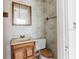 Bathroom with a small vanity, toilet with a wood seat, mirror, floral wallpaper, and a towel rack at 8226 36Th N Ave, St Petersburg, FL 33710