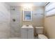 Modern bathroom featuring a tiled walk-in shower, vanity, and neutral-toned walls at 1338 Windsor Way, Tampa, FL 33619