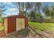 Backyard view showcasing storage shed, well-maintained lawn and mature trees providing shade at 4046 Las Vegas Dr, New Port Richey, FL 34653