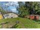 Expansive backyard featuring lush greenery, an exterior storage shed, and fencing at 4046 Las Vegas Dr, New Port Richey, FL 34653
