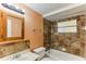 Bathroom showcasing a tiled shower/bath and an oak framed mirror above the sink at 4046 Las Vegas Dr, New Port Richey, FL 34653
