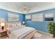Cozy bedroom with blue walls featuring a ceiling fan, plush carpet, two windows and stylish decor at 4046 Las Vegas Dr, New Port Richey, FL 34653