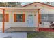 Close up front exterior featuring a white front door, orange shutters, and a small porch at 4046 Las Vegas Dr, New Port Richey, FL 34653