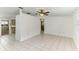 Open-concept living area with tiled flooring, ceiling fan, and view to the kitchen and hallway at 4046 Las Vegas Dr, New Port Richey, FL 34653