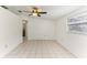 Clean and bright living room featuring tile floors, a ceiling fan, and view to the kitchen and hallway at 4046 Las Vegas Dr, New Port Richey, FL 34653