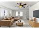 Bright living room featuring a ceiling fan, tile floors, and lots of natural light from the large front windows at 4046 Las Vegas Dr, New Port Richey, FL 34653