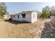 A partially fenced backyard with a view of the back of a single-story home with some boarded-up windows at 1825 134Th St, Largo, FL 33778