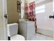 Modest bathroom featuring a bathtub, toilet, and vanity with white tile and a patterned shower curtain at 1825 134Th St, Largo, FL 33778