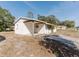 View of single-story home with a carport and partially bricked facade from the side and front at 1825 134Th St, Largo, FL 33778