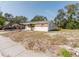 Shows a single-story home with brick accents, a small palm tree, and a carport on a sunny day at 1825 134Th St, Largo, FL 33778