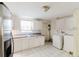 Kitchen featuring white cabinets, a stainless steel refrigerator, and a washing machine at 1825 134Th St, Largo, FL 33778