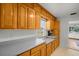 Functional kitchen featuring wood cabinets, light countertops, and an adjacent view into the living area at 8608 N 20Th St, Tampa, FL 33604