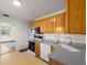 Practical kitchen with white appliances, plenty of wood cabinetry, and access to the living area at 8608 N 20Th St, Tampa, FL 33604