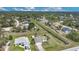 An aerial view of a residential neighborhood featuring a canal, lush trees and well-maintained homes at 7280 Meroni Blvd, North Port, FL 34291