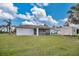 This is a view of the home's backyard with a grassy lawn and screened in porch at 7280 Meroni Blvd, North Port, FL 34291