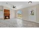 Bright living room with tile flooring, fireplace, ceiling fan and natural light from large window at 7280 Meroni Blvd, North Port, FL 34291