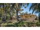 Spacious backyard featuring mature trees providing shade and a charming covered patio with outdoor seating at 1825 Alberta Dr, Clearwater, FL 33756