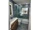 Bathroom featuring updated vanity, blue tiling, and a glass enclosed tub at 1825 Alberta Dr, Clearwater, FL 33756