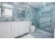 Stunning bathroom with blue marble walls, glass shower, and modern white vanity at 1825 Alberta Dr, Clearwater, FL 33756