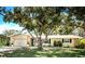 Charming one-story home with mature tree, manicured lawn, and neutral exterior paint at 1825 Alberta Dr, Clearwater, FL 33756