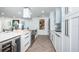 Bright kitchen features white cabinets, stainless steel appliances, herringbone floors, and a wine cooler at 1825 Alberta Dr, Clearwater, FL 33756
