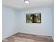 Well-lit bedroom with wood flooring and a window overlooking a palm tree at 5729 Baywater Dr # 5729, Tampa, FL 33615