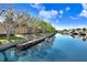 Scenic waterfront view with a wooden dock, boat, and multi-story condo buildings along canal at 5729 Baywater Dr # 5729, Tampa, FL 33615