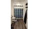 Bathroom with wood look flooring, patterned shower curtain and vanity with granite countertops at 11856 Throttle Pl, Gibsonton, FL 33534