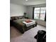 Cozy bedroom featuring a bed with a green comforter, nightstand, and a view from the window at 11856 Throttle Pl, Gibsonton, FL 33534