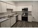 Well-lit kitchen featuring stainless steel appliances, granite countertops and white cabinets at 11856 Throttle Pl, Gibsonton, FL 33534