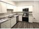 Bright kitchen features white cabinets, granite countertops, and stainless steel appliances at 11856 Throttle Pl, Gibsonton, FL 33534