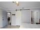 Bedroom featuring a barn door, neutral paint, and light-colored wood-look flooring at 11144 Summer Star Dr, Riverview, FL 33579