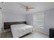 Bedroom with a ceiling fan, wood floors, and a modern headboard and side table at 11144 Summer Star Dr, Riverview, FL 33579