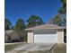 Two-car detached garage with concrete driveway and a neutral color palette at 12403 Snowy Egret Ave, Weeki Wachee, FL 34614