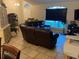 Living room with tile floors, leather furniture, and a large window at 12403 Snowy Egret Ave, Weeki Wachee, FL 34614
