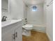Bright bathroom featuring a white vanity, toilet and shower/tub combo with tiled walls and a unique octagonal window at 3527 65Th Avenue E Cir, Sarasota, FL 34243